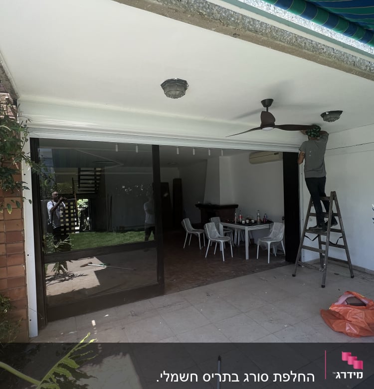 אדם על סולם ליד מסגרת אלומיניום